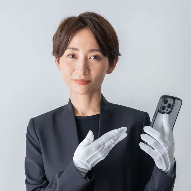 白い手袋を着けてスマートフォンを持つ女性スタッフ