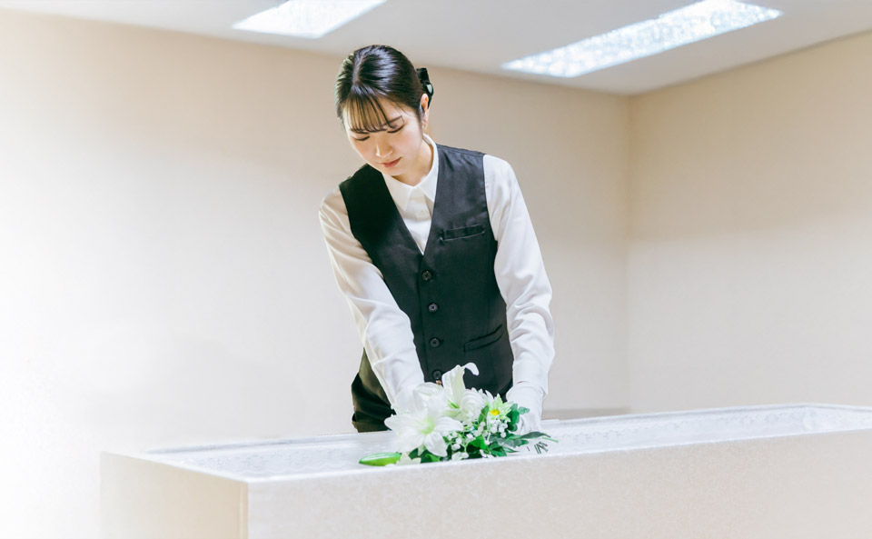 安置した故人様に花を手向けるスタッフ