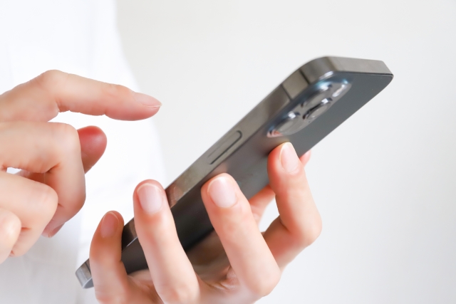 スマートフォンを操作する人の手元